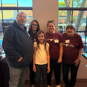 A family, a man, three women, and a young girl posing for a picture at the 2025 Banking for the Community event.